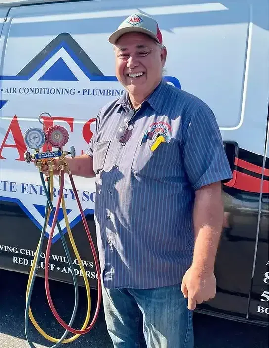 A man is standing in front of a van holding a bunch of hoses.