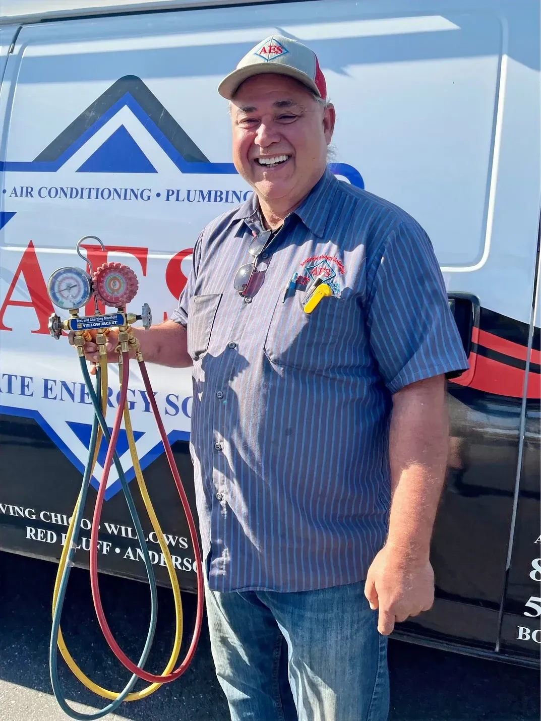 A man is standing in front of a van holding a bunch of hoses.