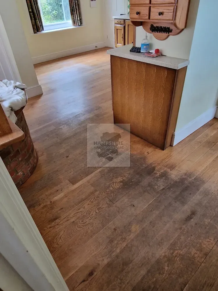 Wooden floor in a room. Cabinet and a window are visible.