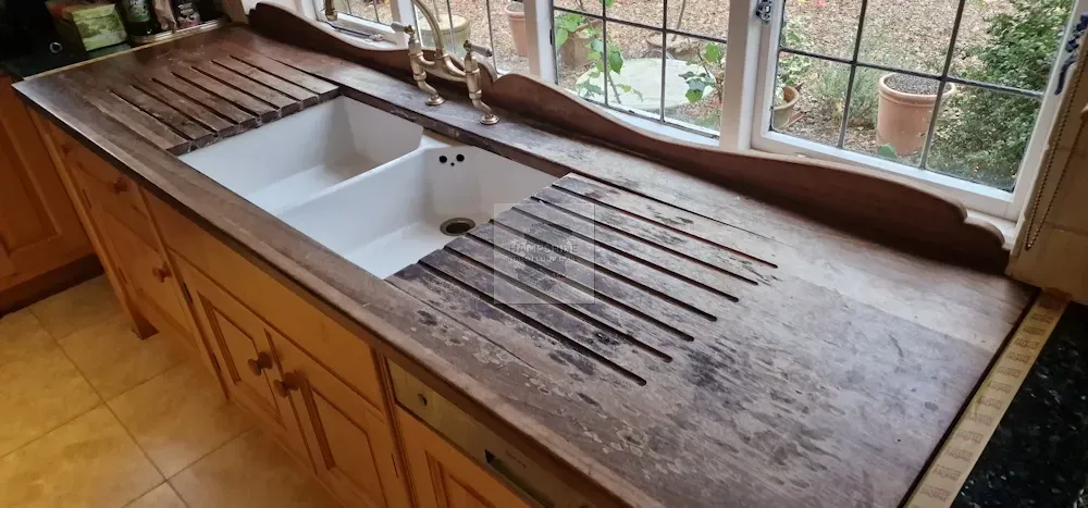Kitchen with wooden cabinets, a sink, and a window.