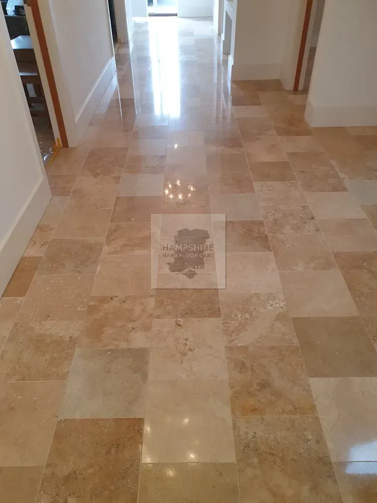 Tiled floor in a hallway; beige and tan tiles reflecting light; doorways on either side.