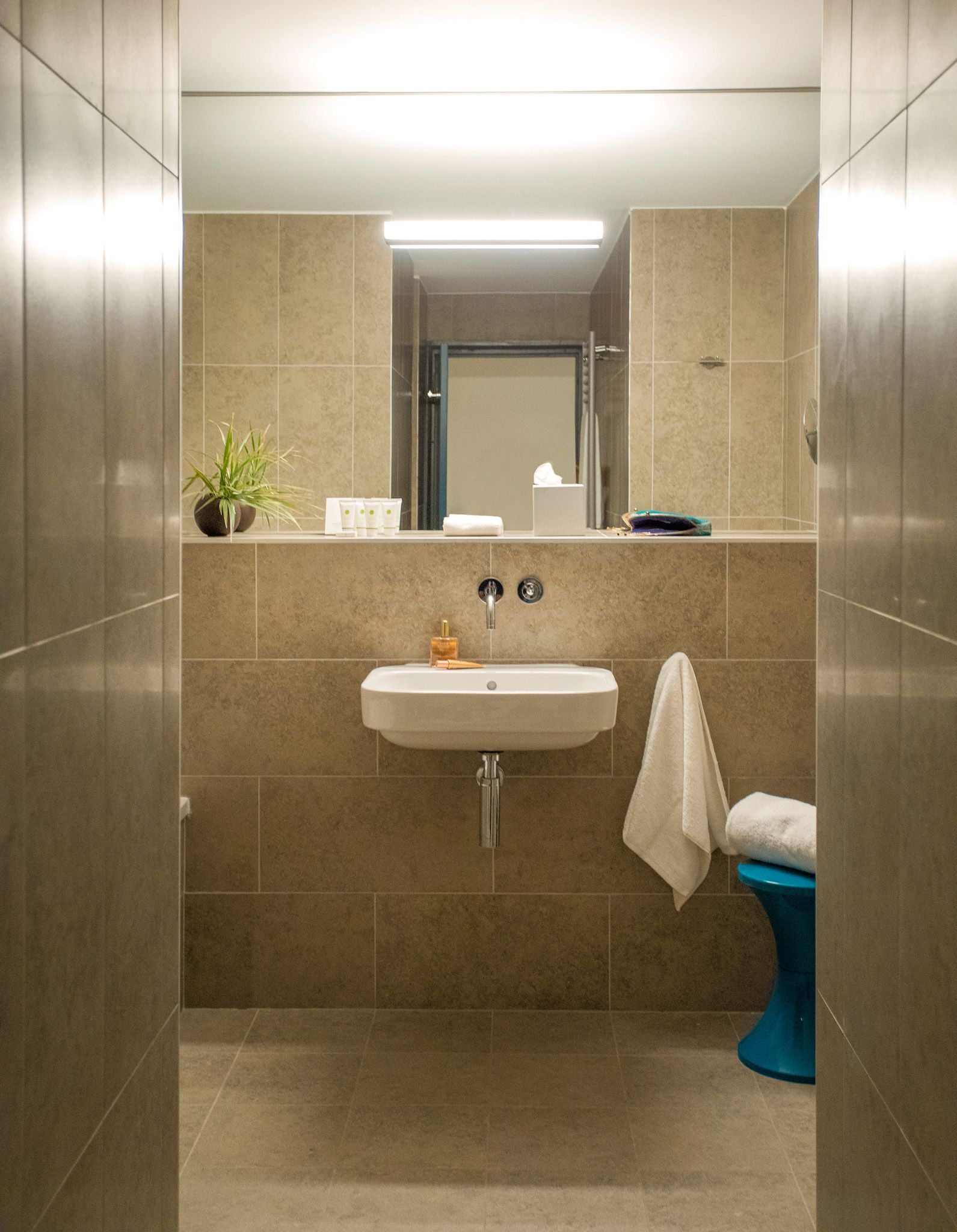 A bedroom with red walls , a large bed , a desk and a fireplace.