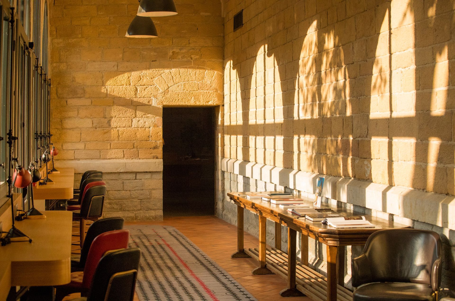 A living room with red walls , a couch , chairs and a rug.