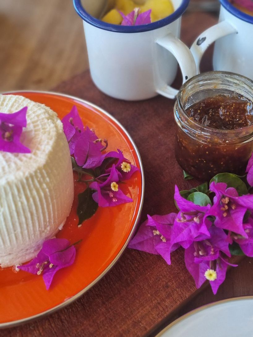 A plate of food with purple flowers and a jar of jam