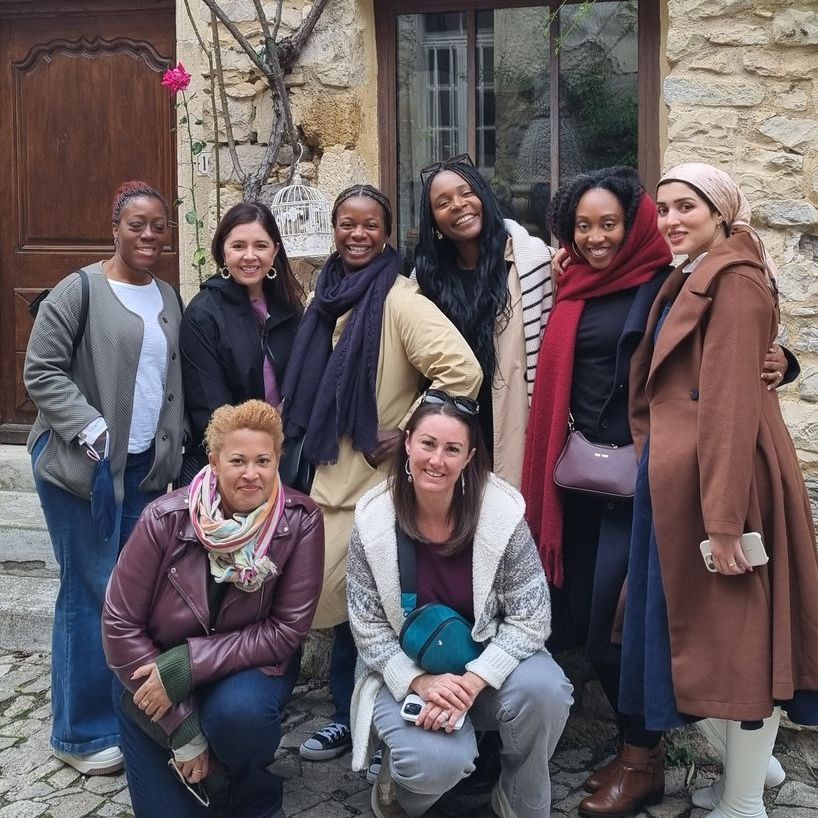 A group of women posing for a picture in front of a building