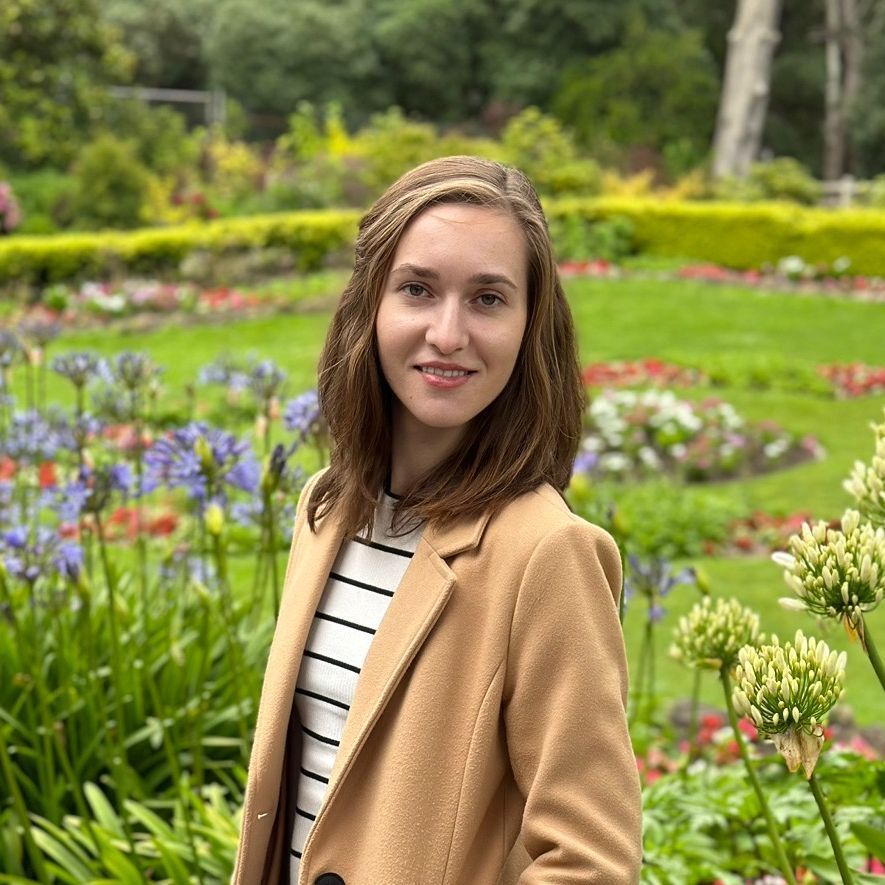 A man standing behind a counter holding a plate of food