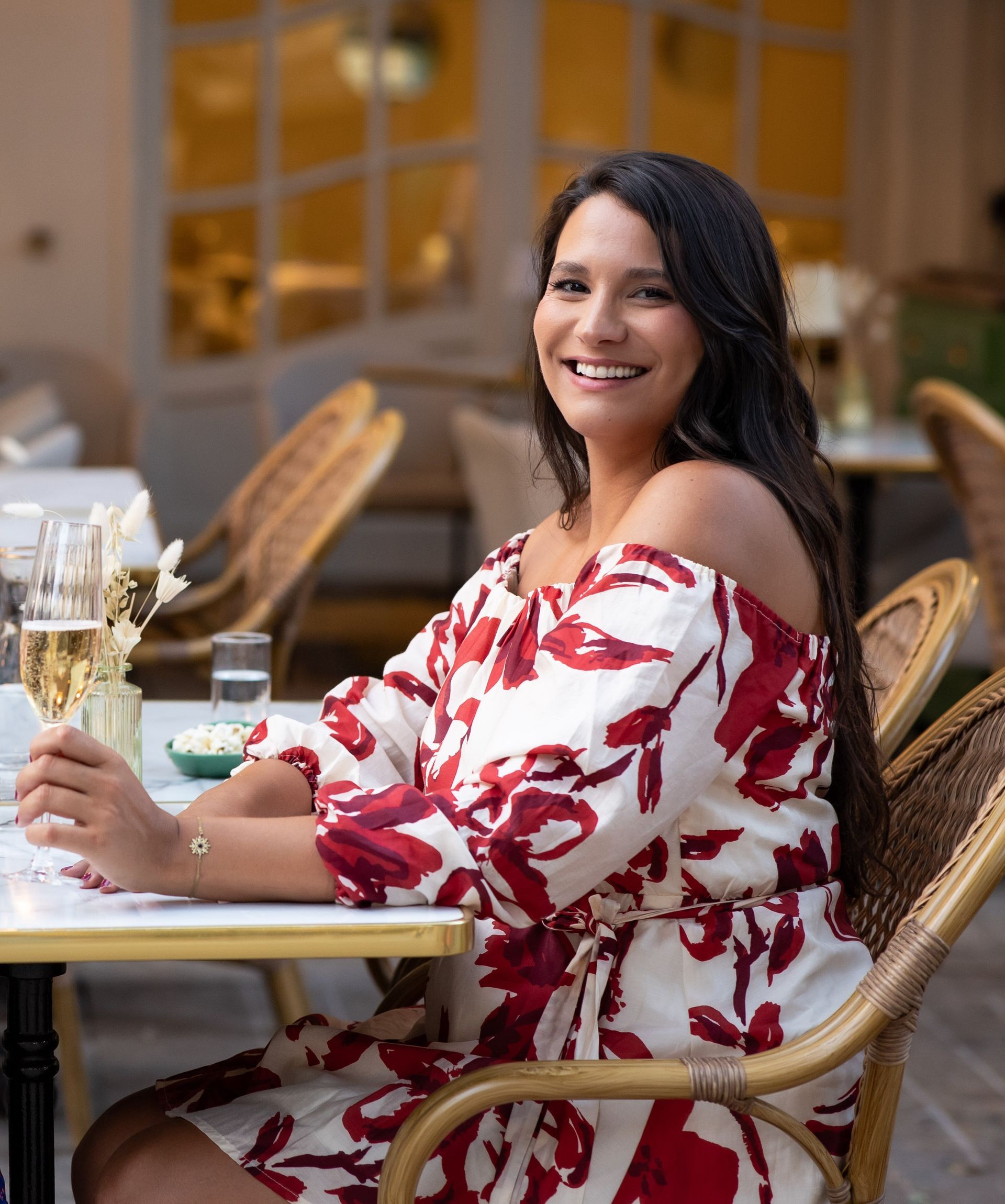 A black and white photo of a woman smiling in front of a window.