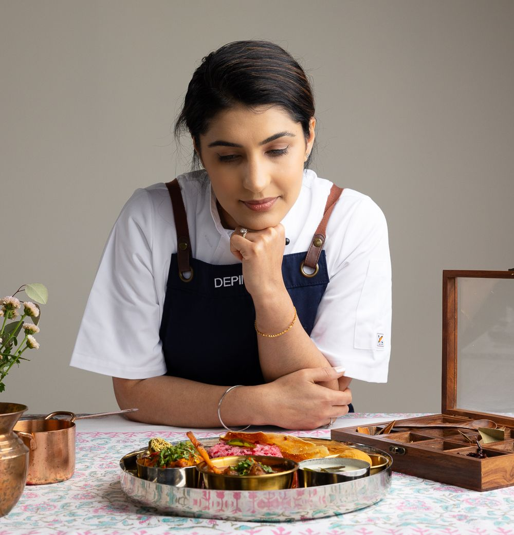 A woman in a white shirt is smiling and looking at the camera.