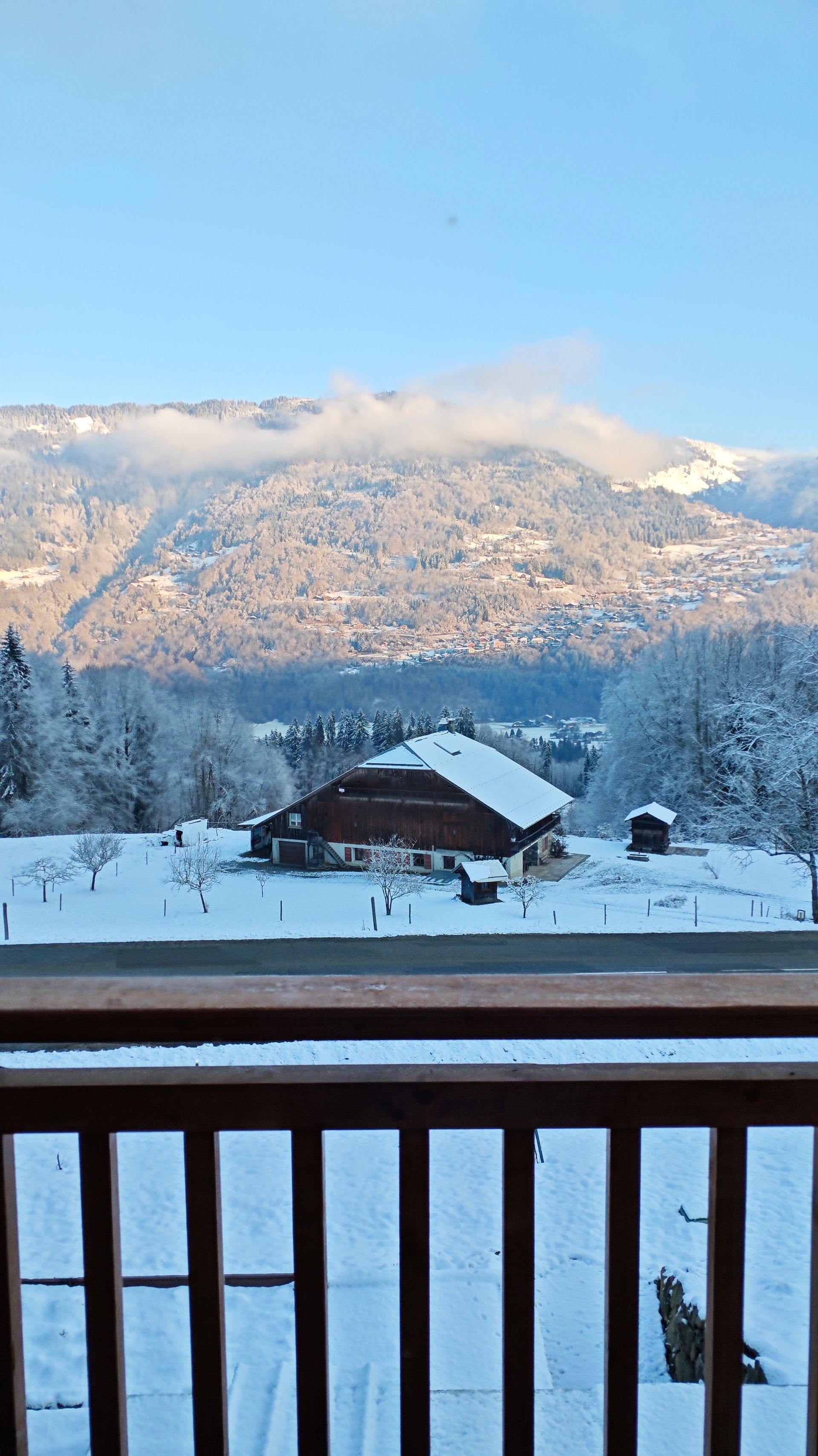 A view of a snowy mountain range from a balcony.