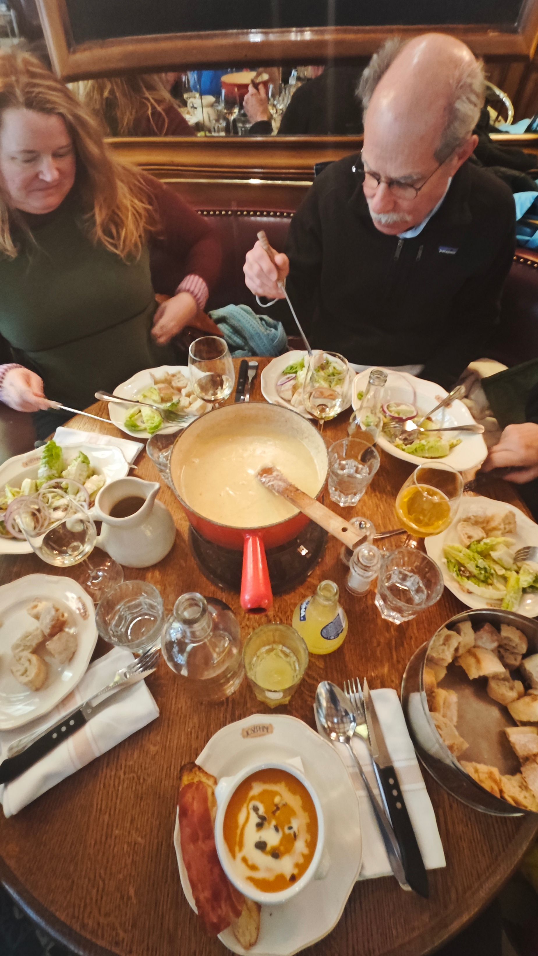 A man and a woman are sitting at a table eating fondue.