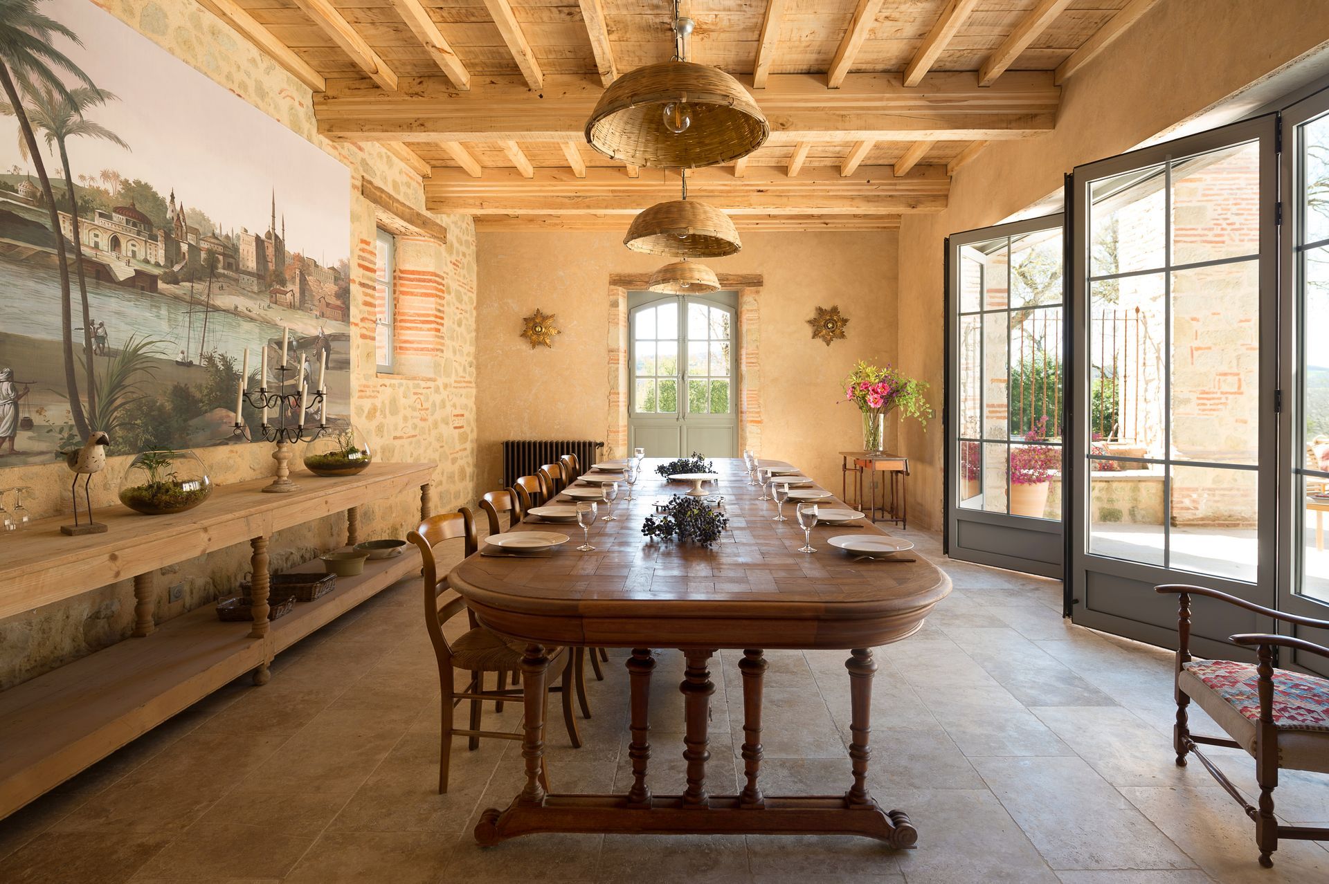 A bedroom with red walls , a large bed , a desk and a fireplace.
