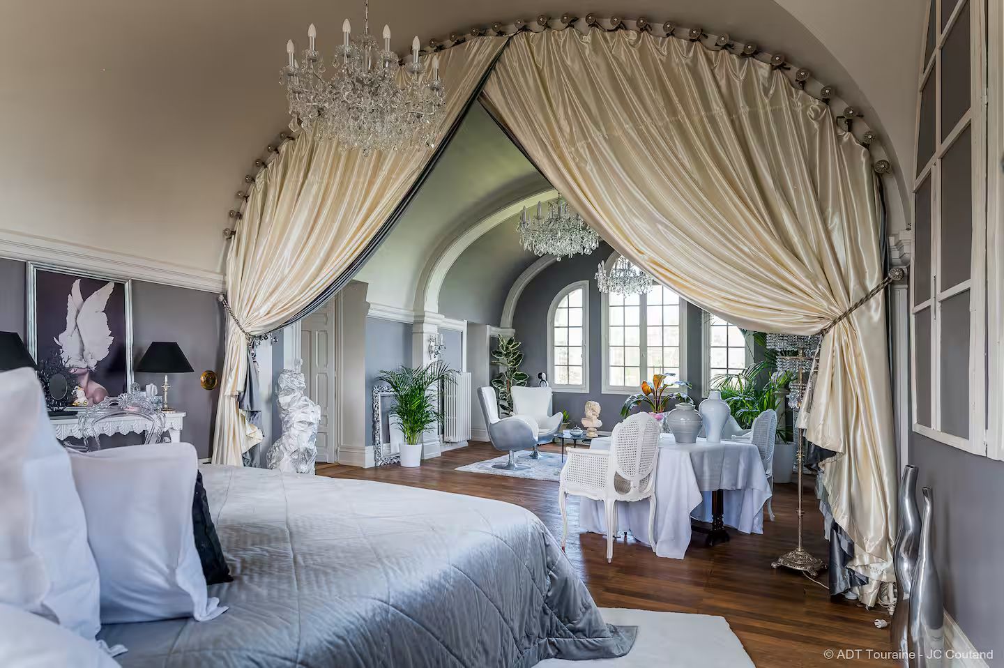 A bedroom with a bed , chair , table and window.