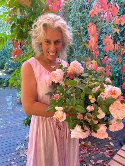 A woman in a pink dress is holding a bouquet of flowers.
