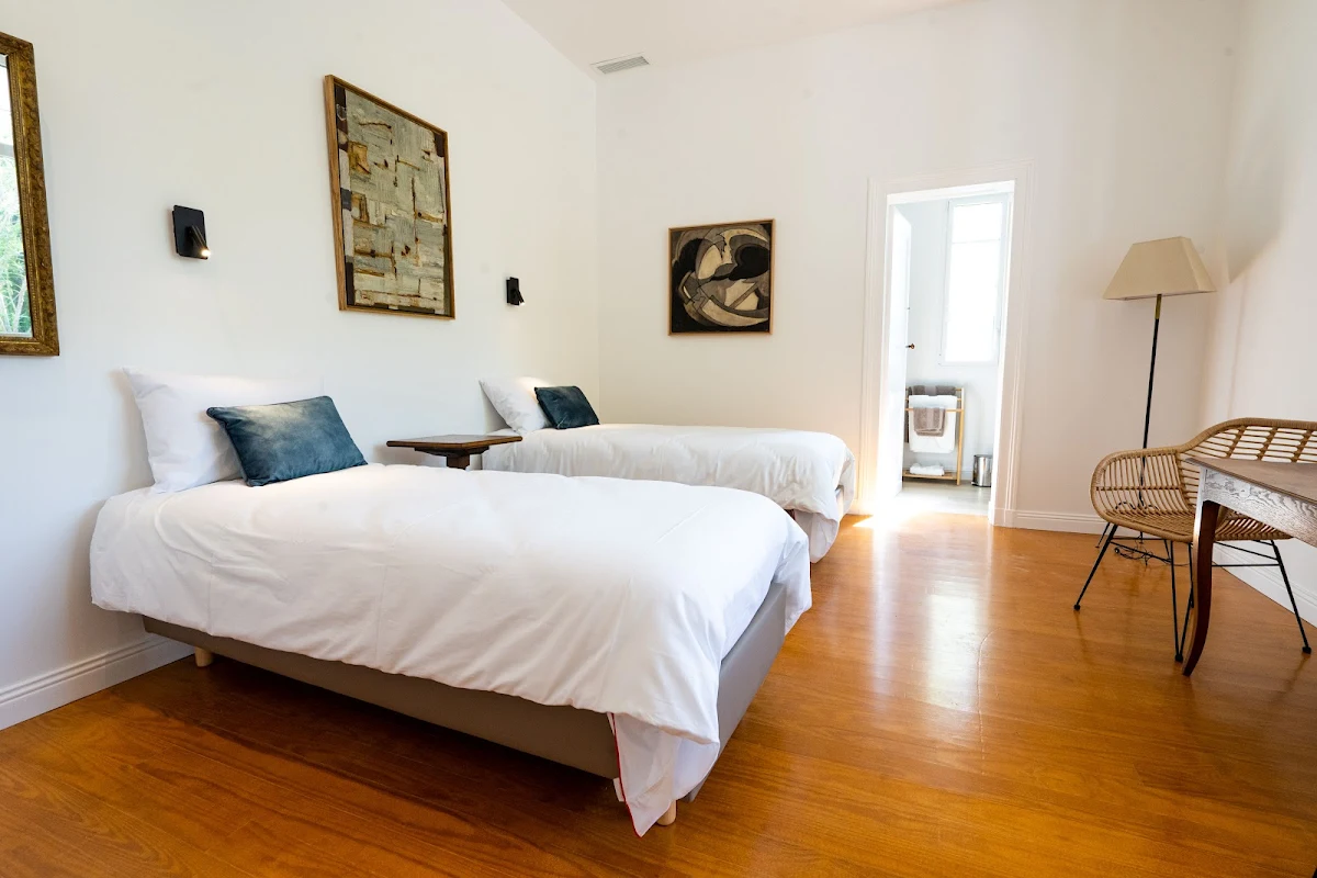 A bedroom with two beds , a desk and a chair.