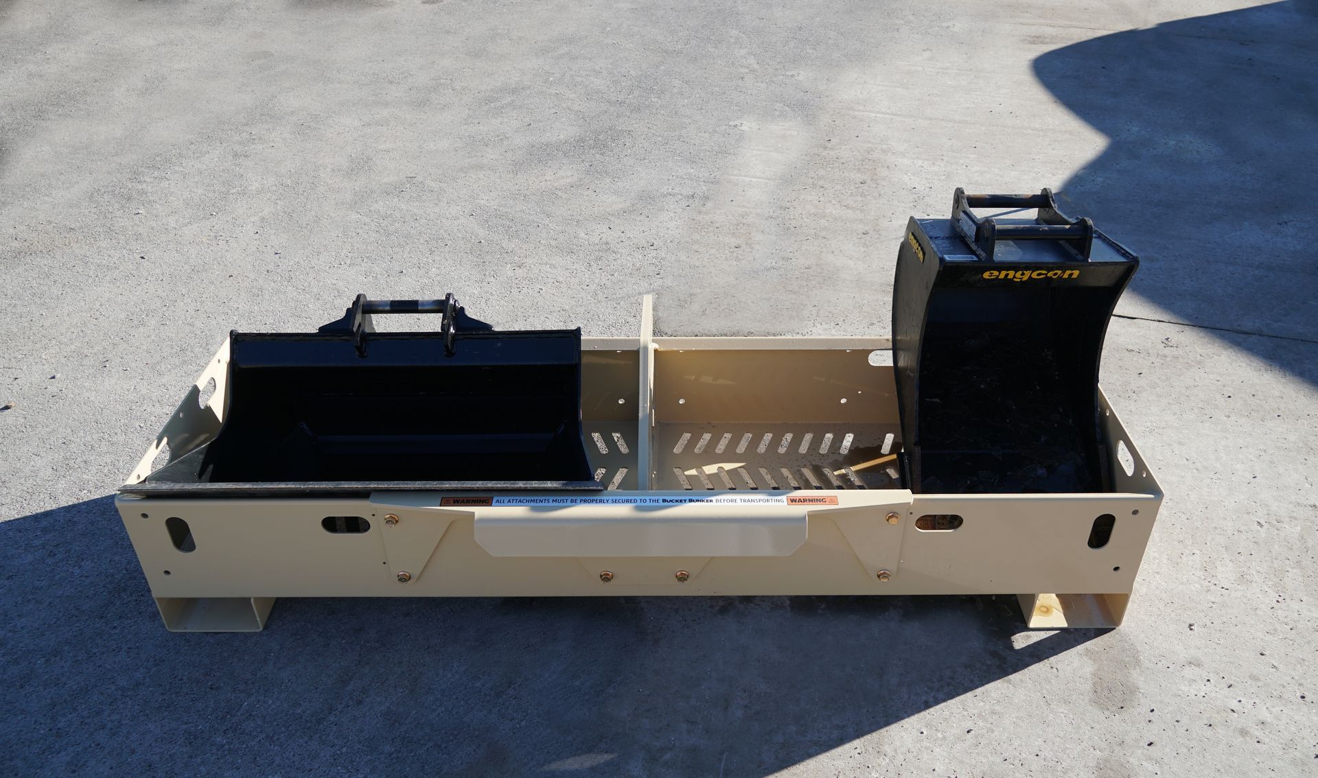 A bucket bunker mini-ex 2t has buckets in it and is sitting on the ground. 