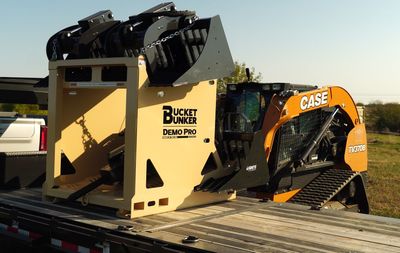 A case track loader and a bucket on a trailer