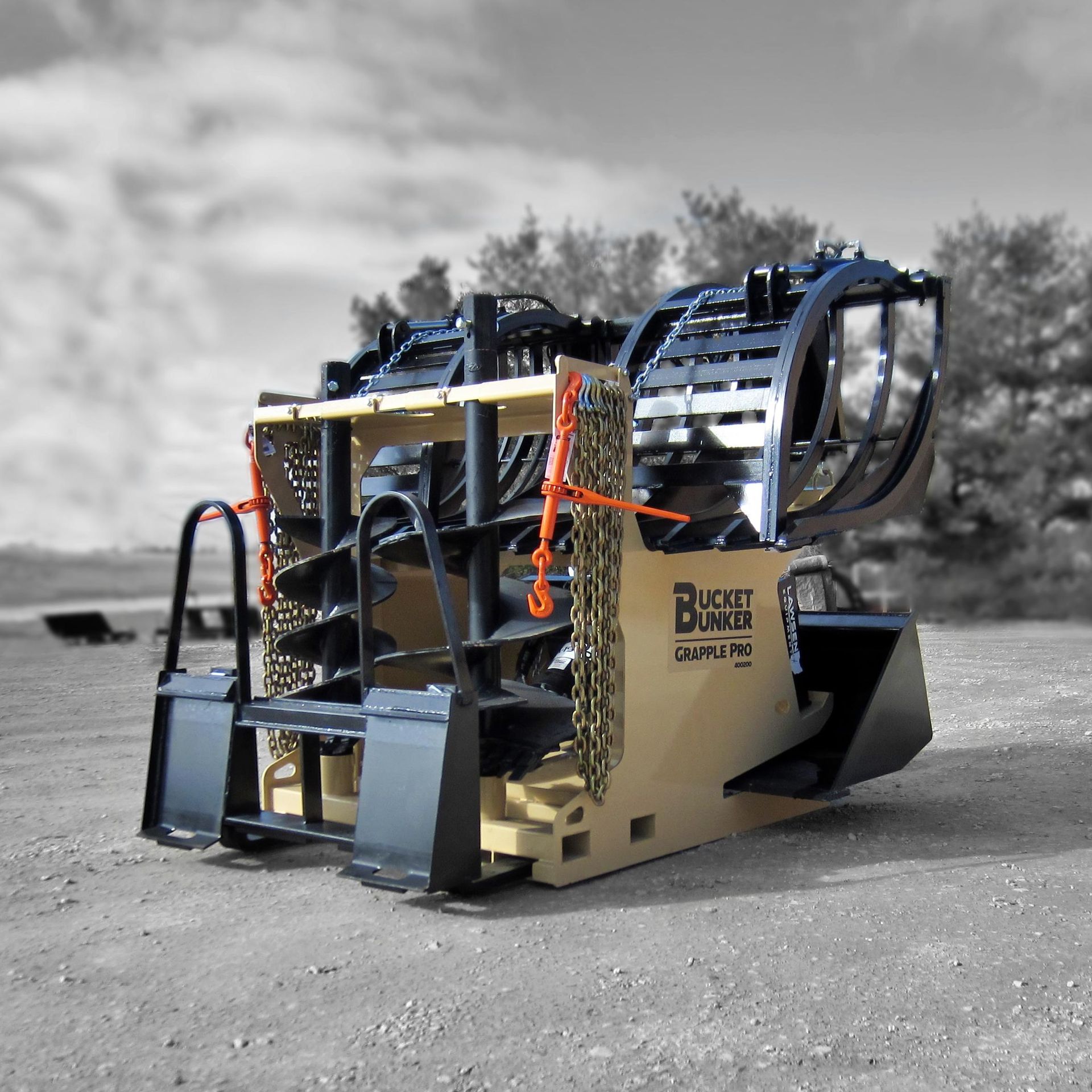 A bucket bunker grapple pro is sitting on gravel