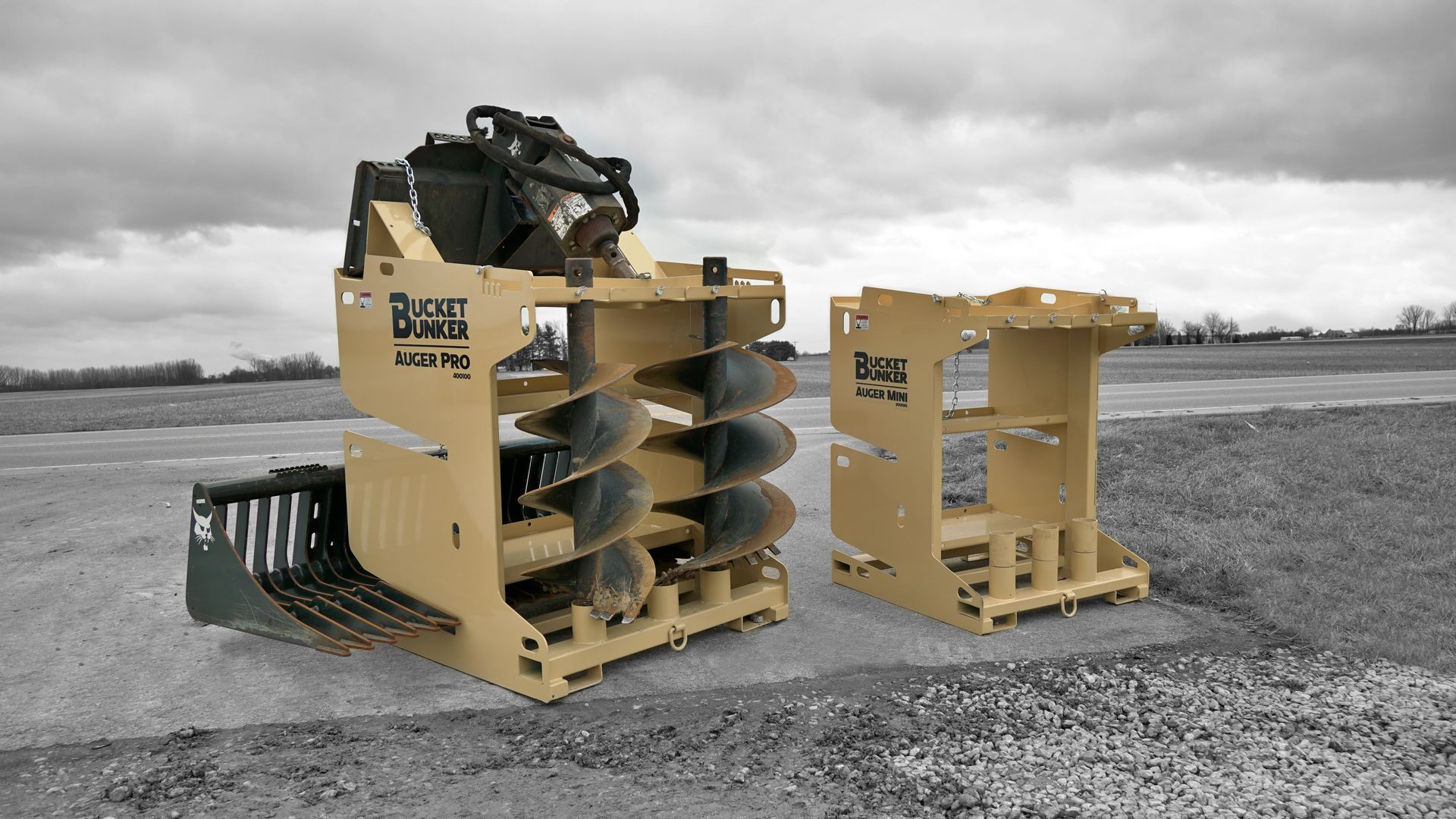 Two bucket bunkers are sitting on top of a gravel road.