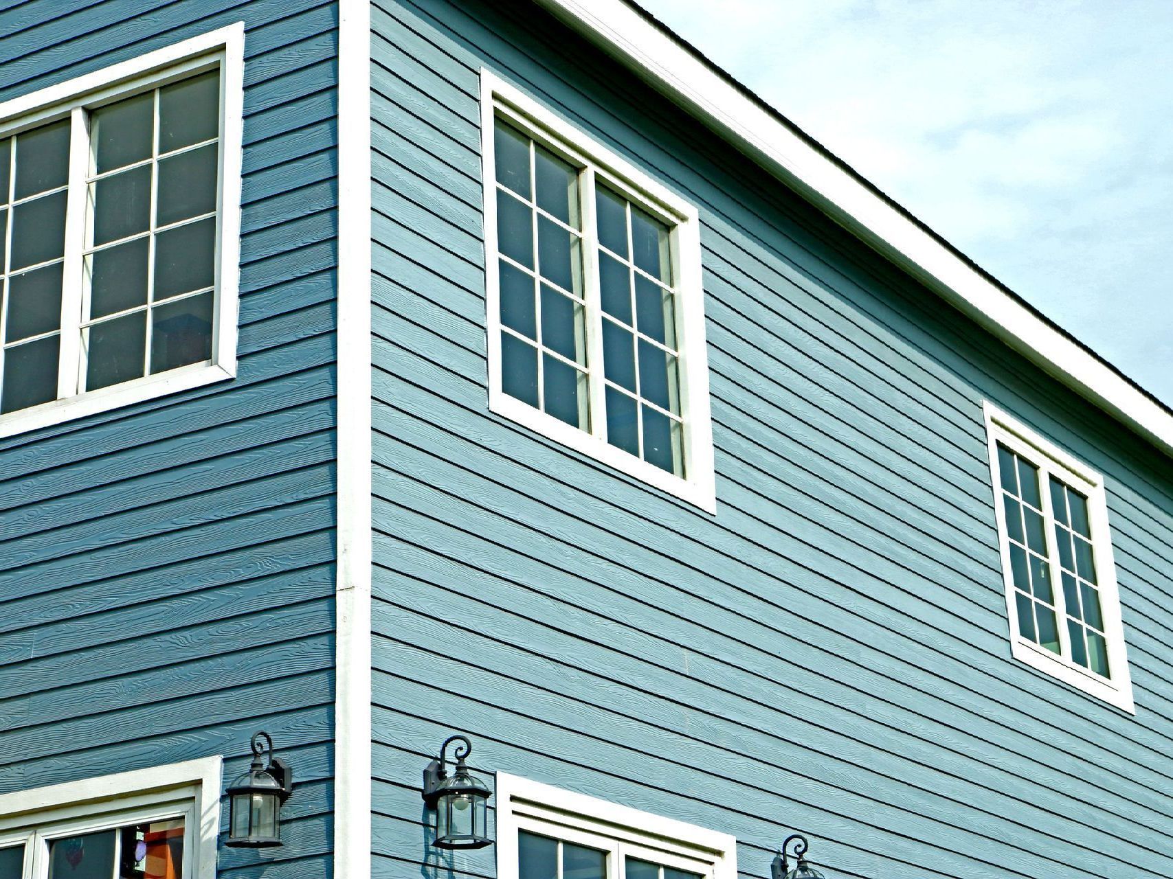 A blue house with white trim and many windows