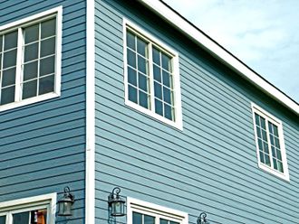A blue house with white trim and many windows