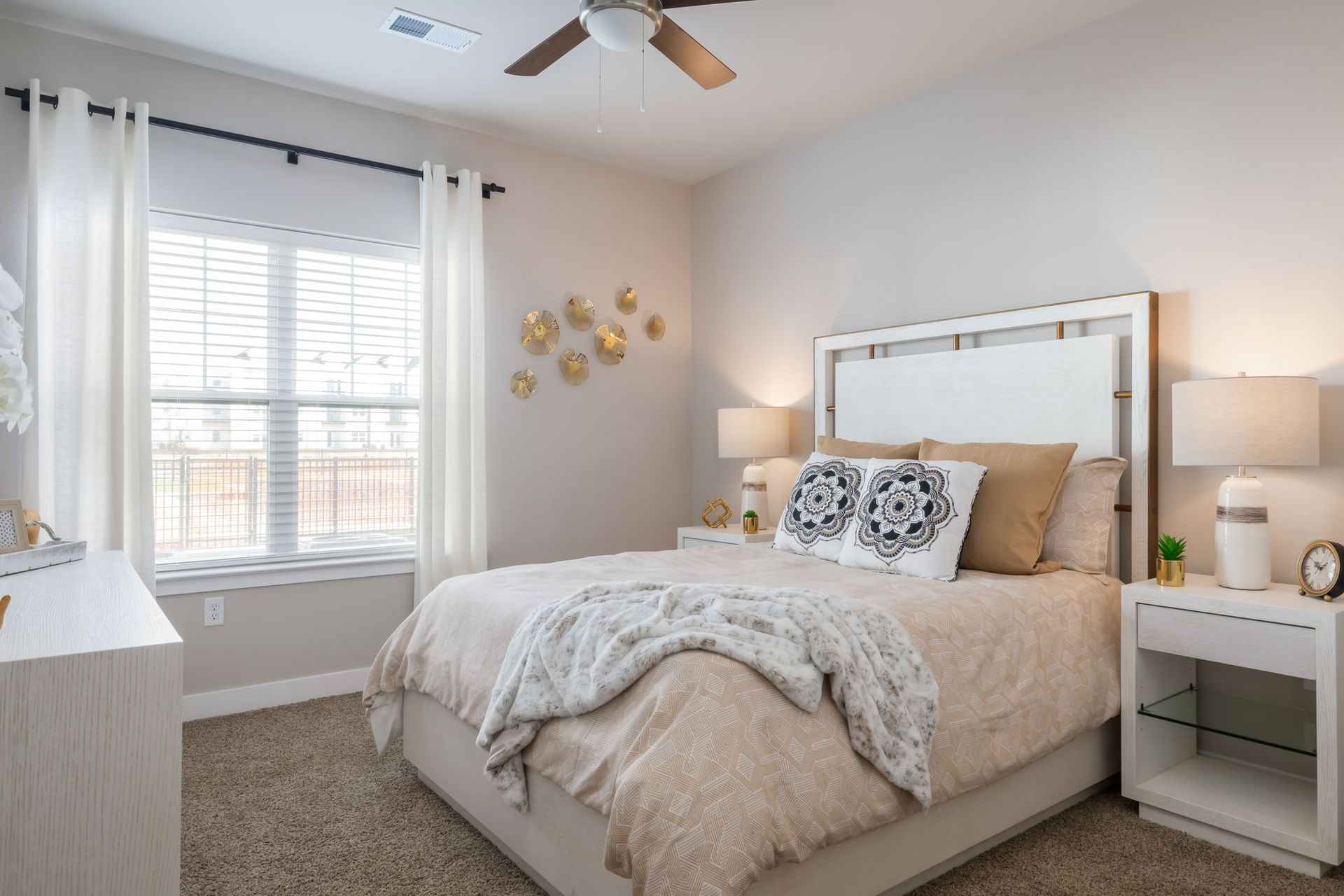 A bedroom with a bed , nightstand , dresser and ceiling fan.