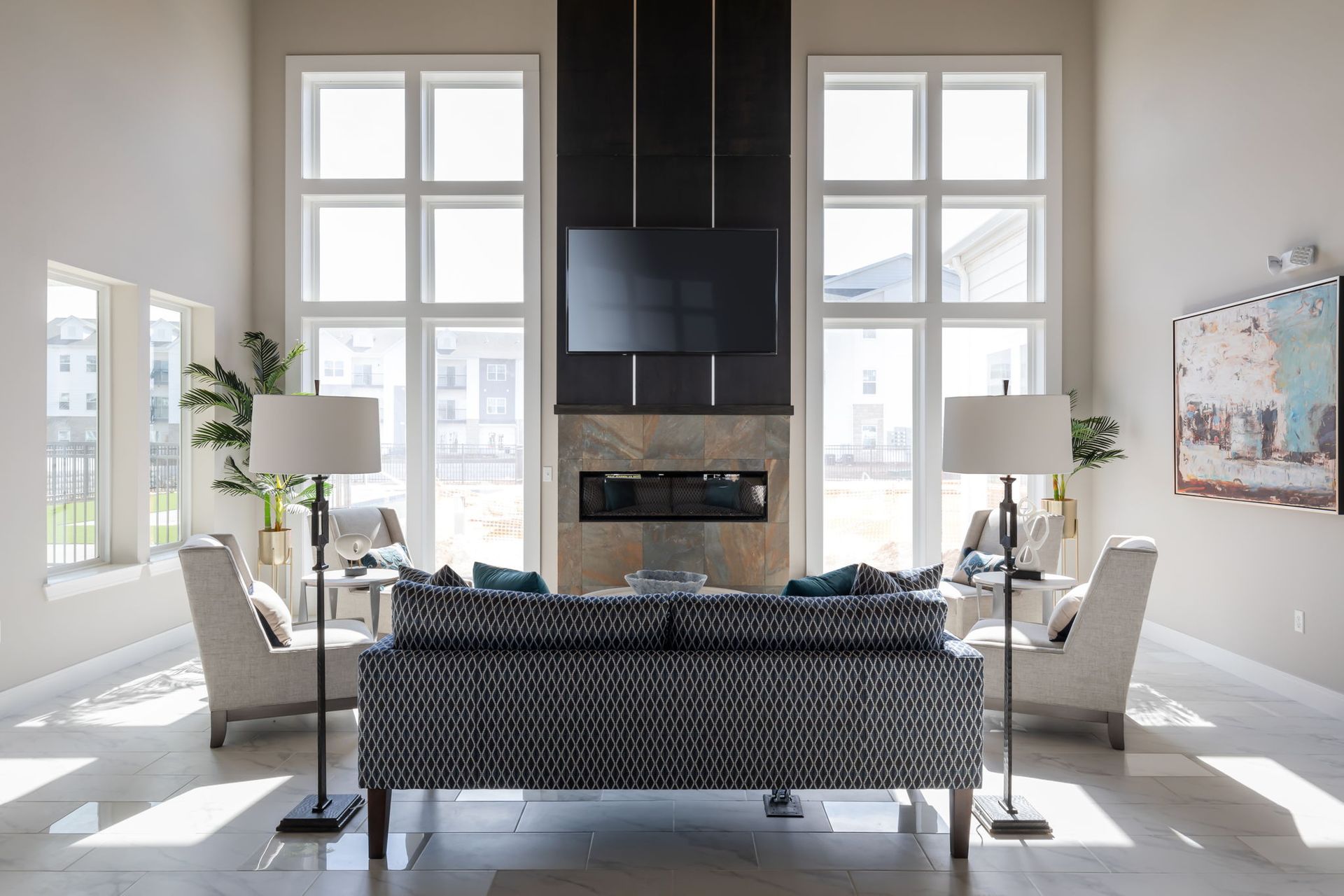 A living room with a couch , chairs , lamps and a fireplace.