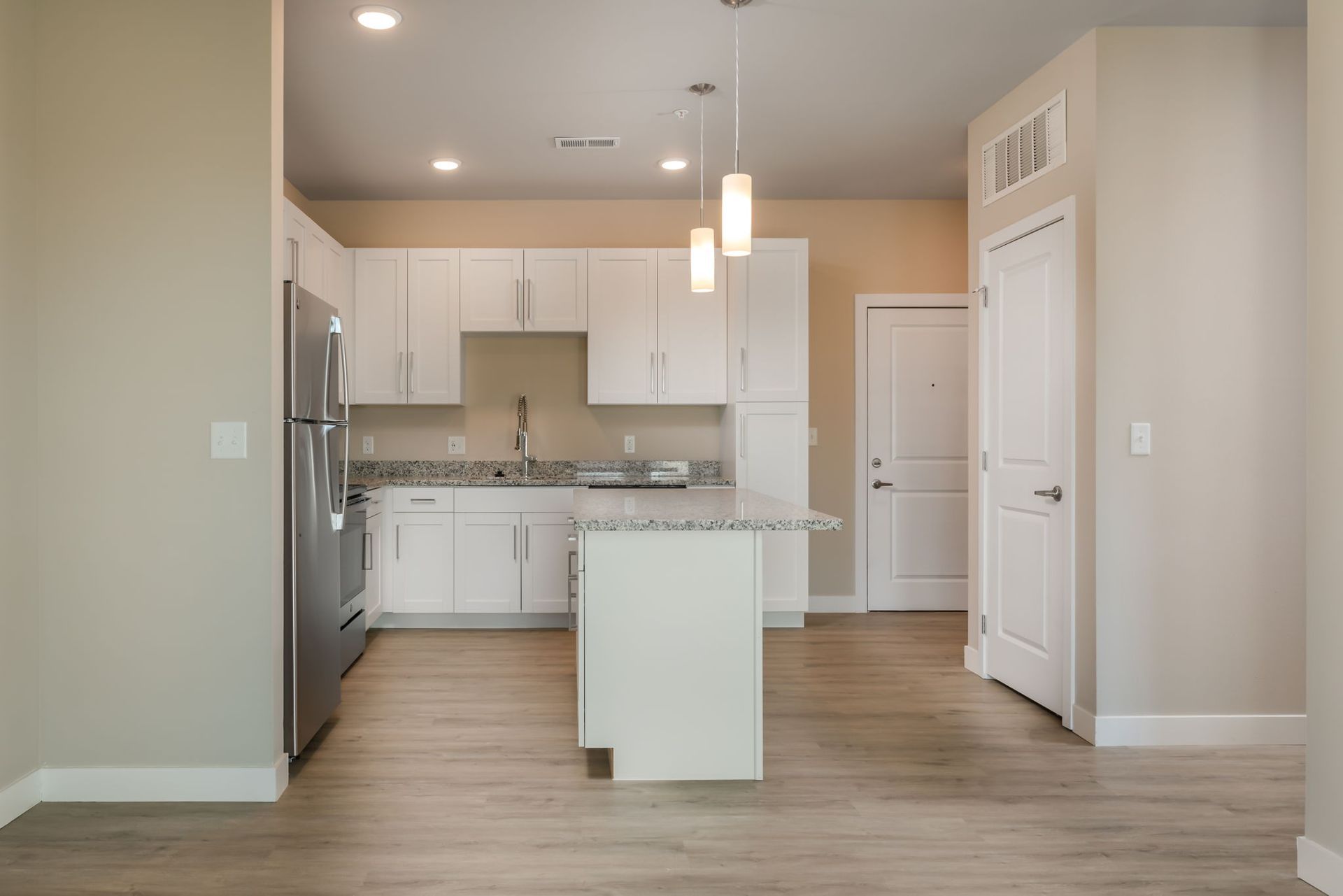 A kitchen with white cabinets and stainless steel appliances