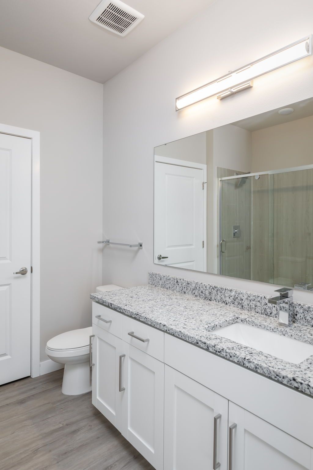 A bathroom with a toilet , sink , and mirror.