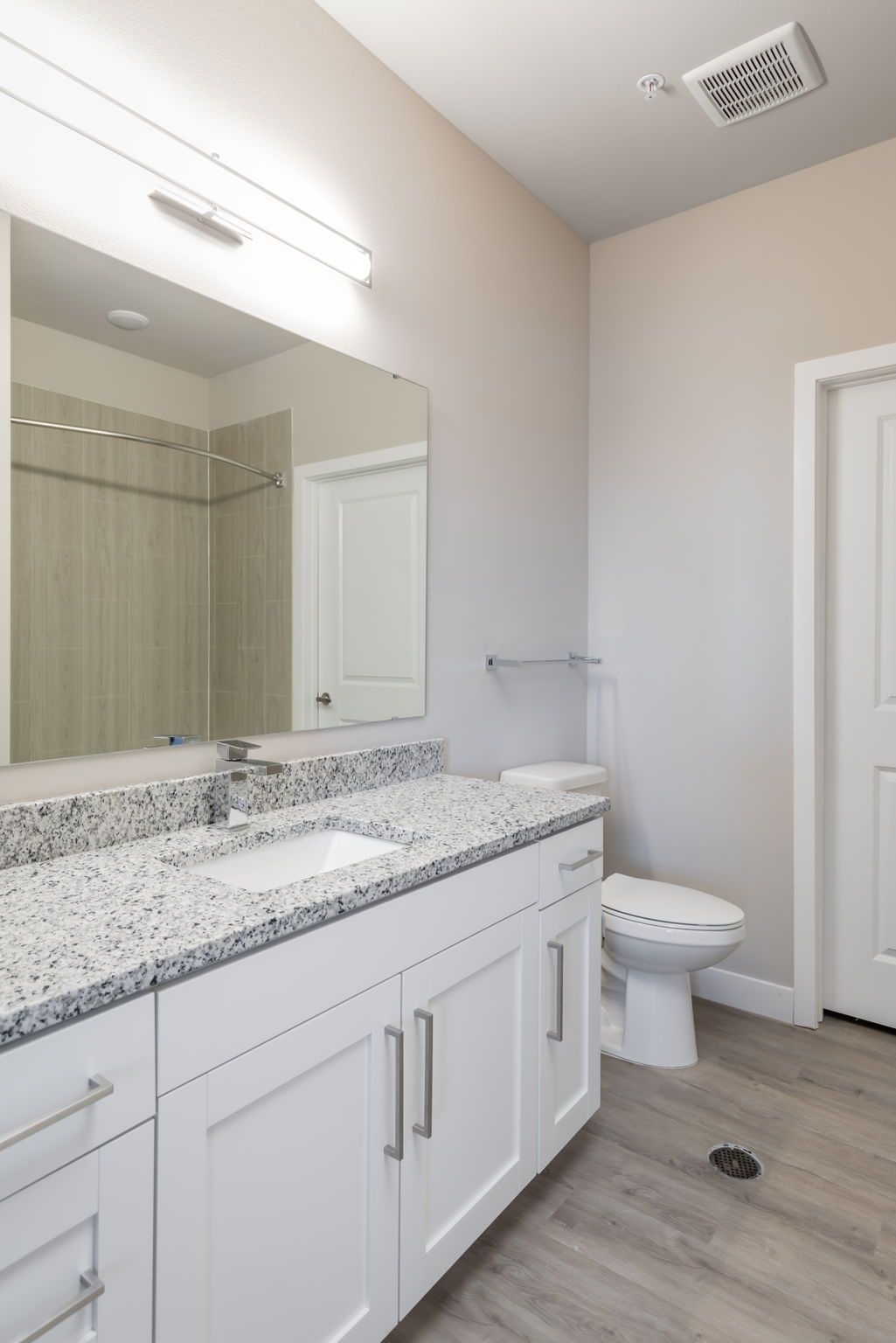 A bathroom with a sink , toilet and mirror.