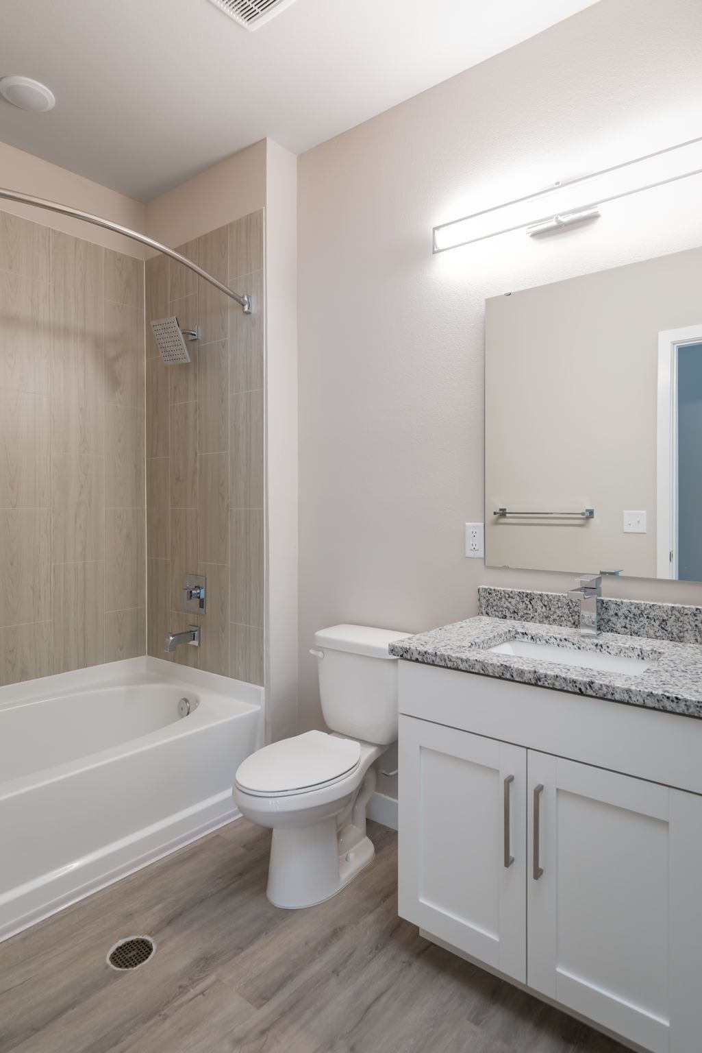 A bathroom with a tub , toilet , sink and mirror.