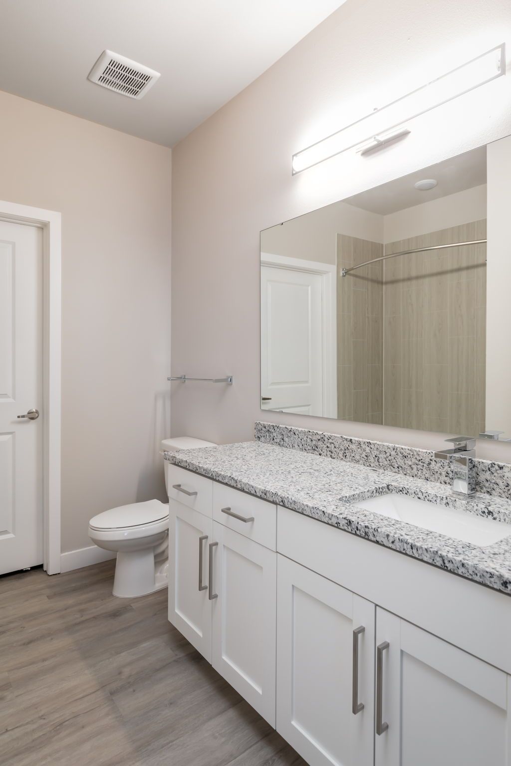 A bathroom with a toilet , sink and mirror
