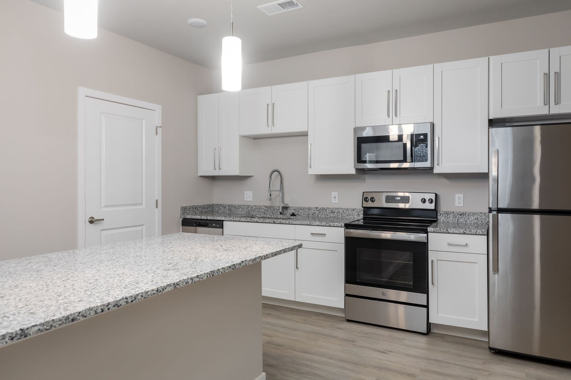 A kitchen with white cabinets and stainless steel appliances
