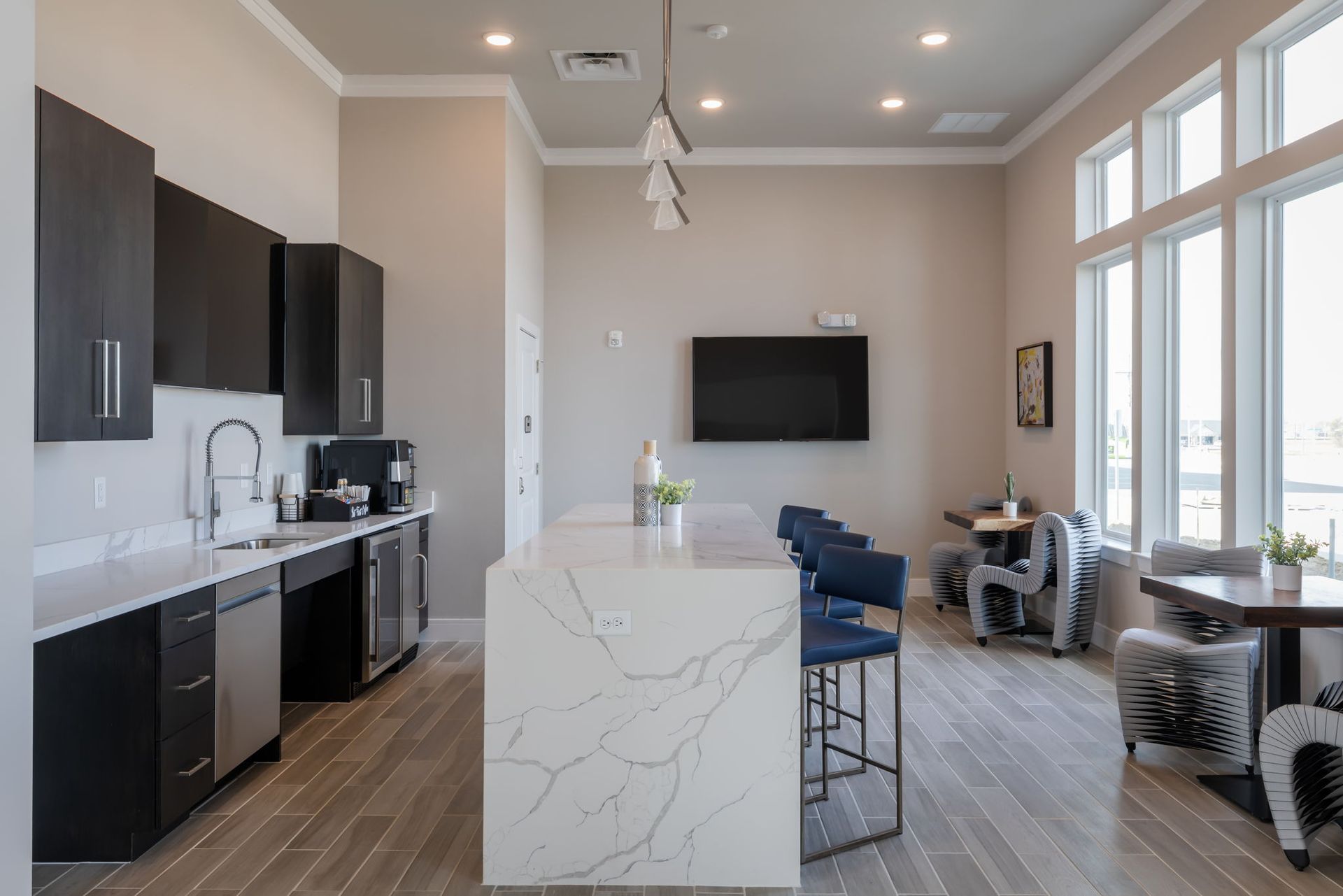 A kitchen with a large island and a flat screen tv on the wall.