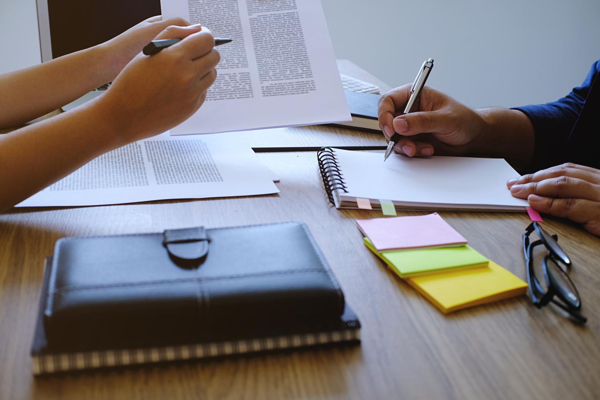 Magnifying glass over a person, surrounded by others.