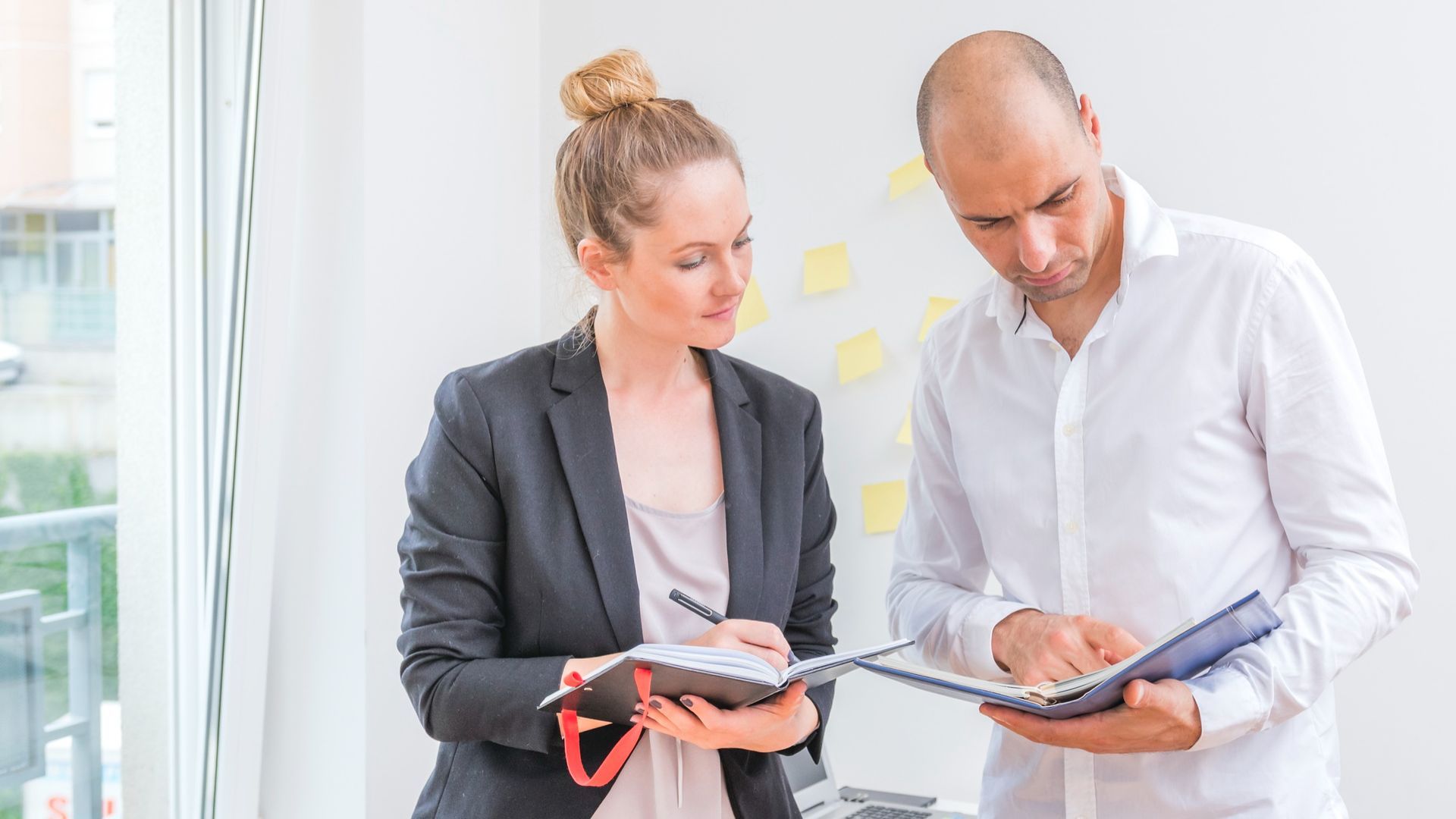 A man and a woman are looking at a clipboard during a workplace investigation