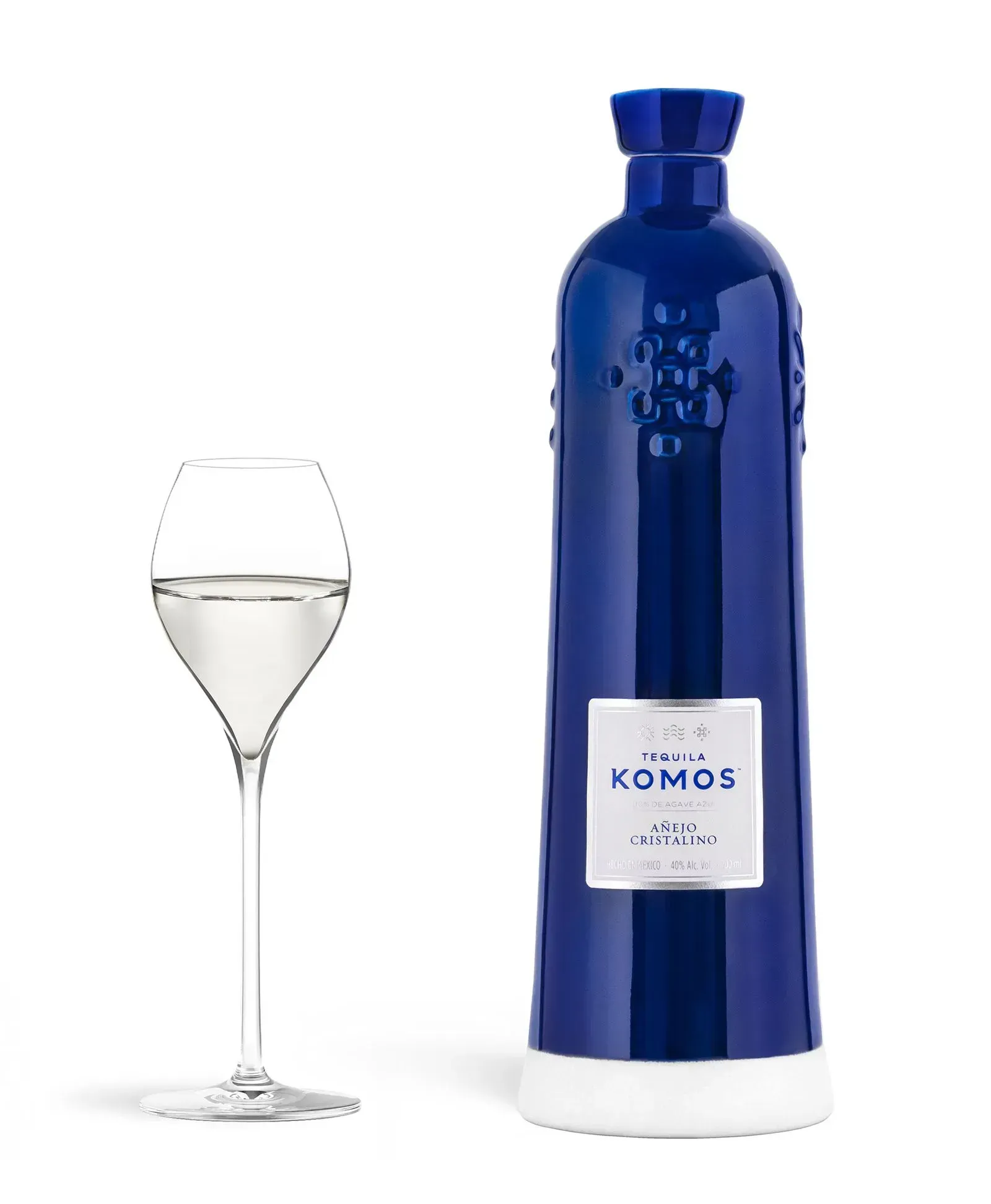 Blue tequila bottle and glass with clear liquid, on a white background.