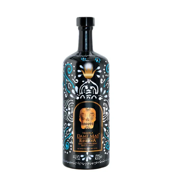 Bottle of tequila with black background, intricate gold and turquoise design, and skull label.