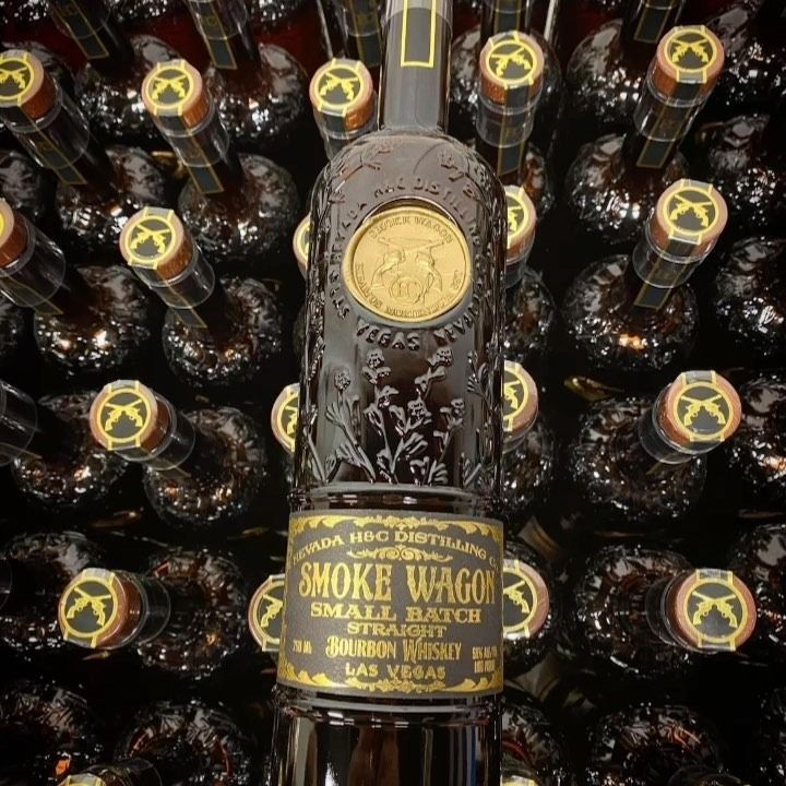 A bottle of Smoke Wagon Bourbon Whiskey with many similar bottles in the background.