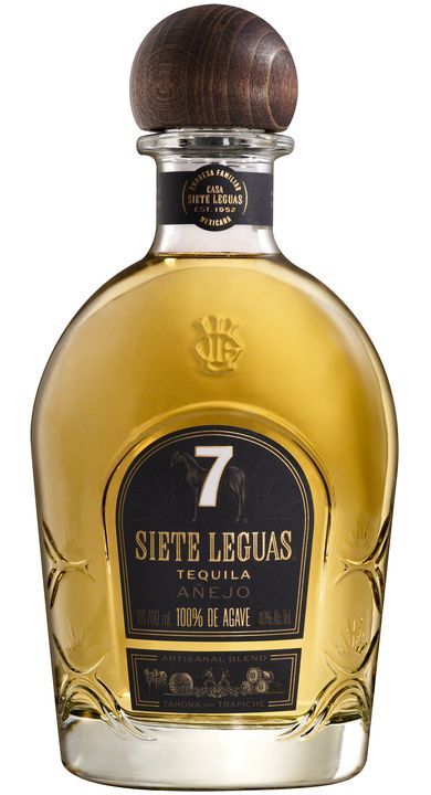 Siete Leguas Añejo tequila bottle with a wooden stopper. Golden liquid against a black and gold label.