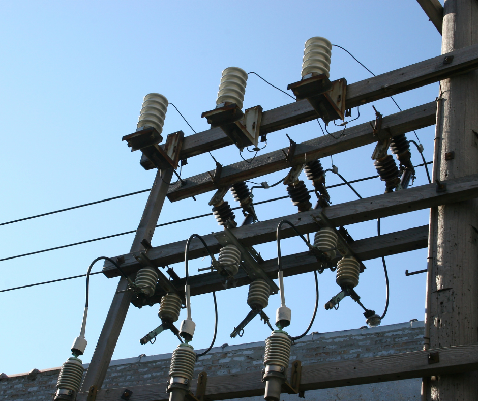 A bunch of electrical wires are hanging from a pole