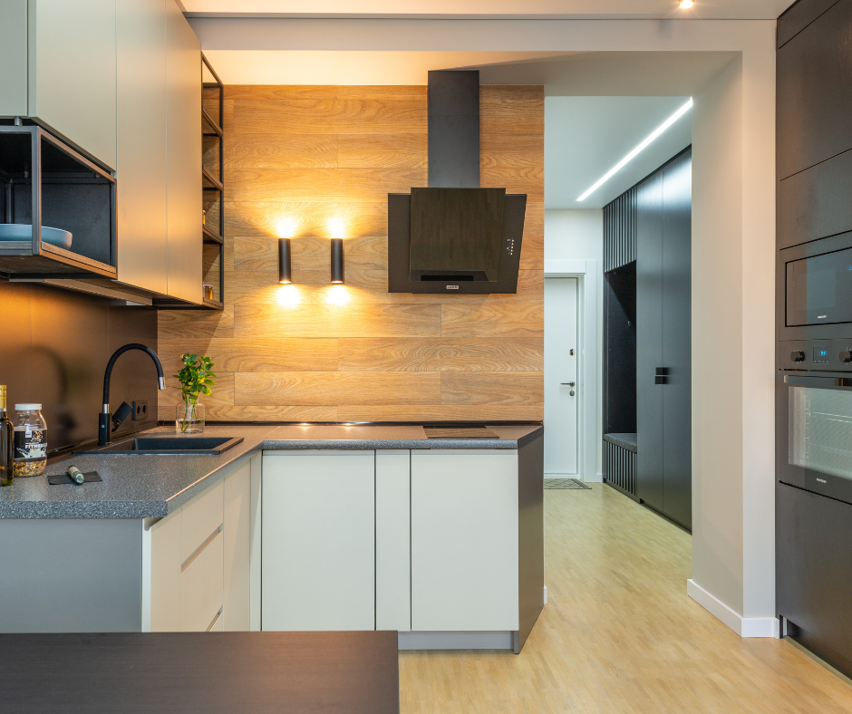 A kitchen with white cabinets and a wooden wall