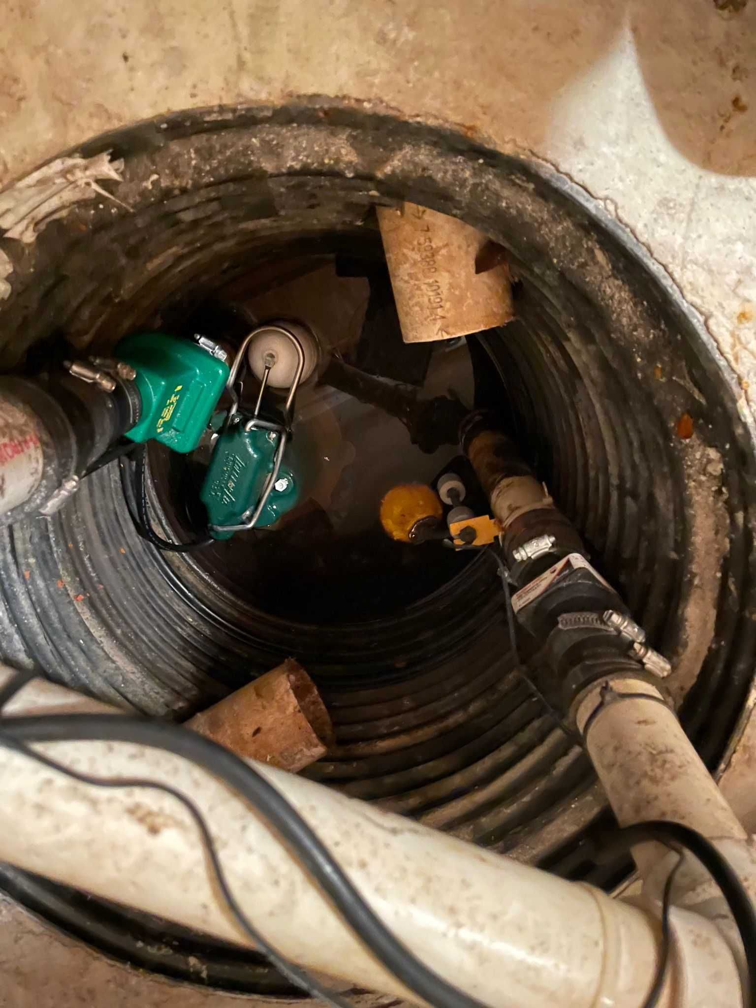 A close up of a drain with a bunch of pipes coming out of it.