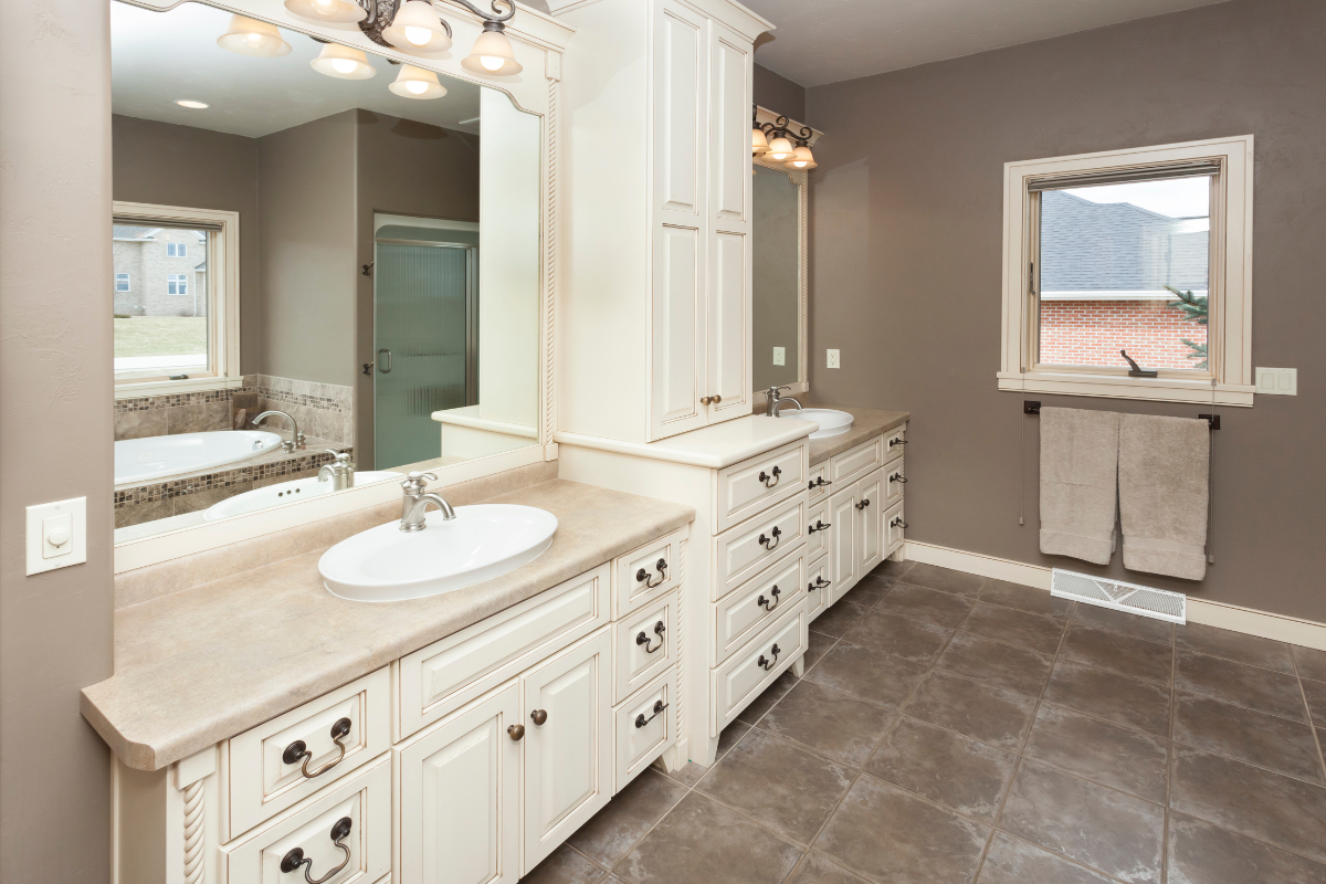 A bathroom with two sinks , two mirrors , and a window. Menke Inc. Abilene, TX