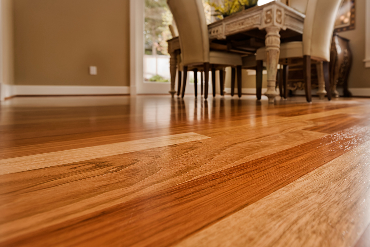 A wooden floor in a dining room with a table and chairs.