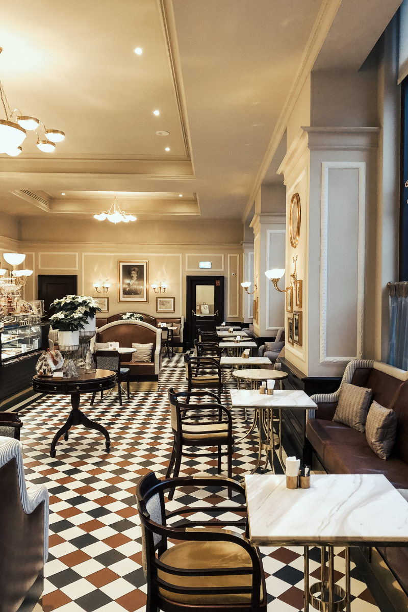 A restaurant with tables and chairs and a checkered floor.