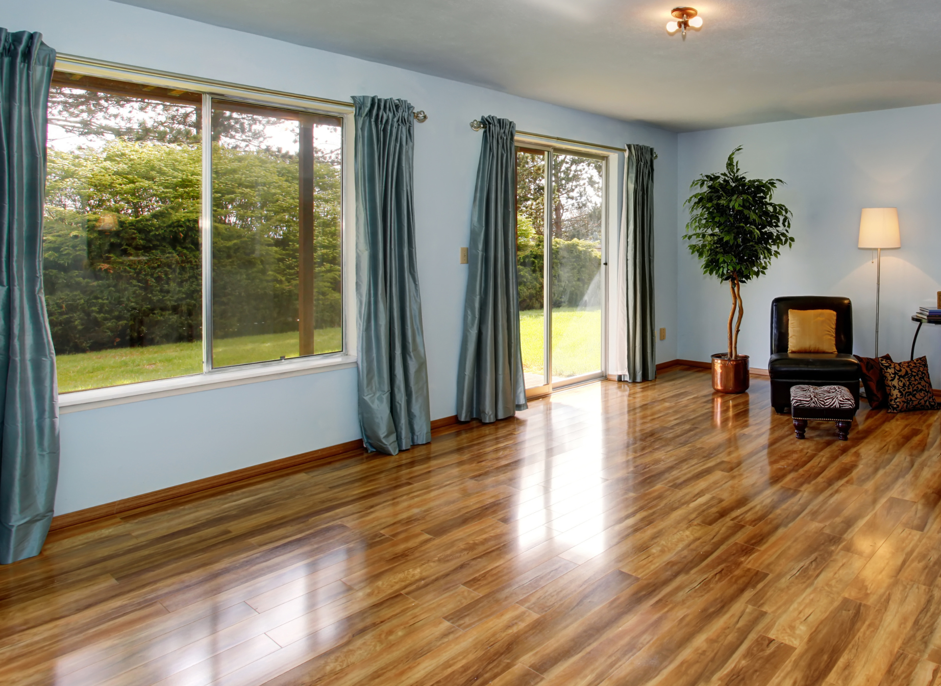 A wooden floor with chairs and a table in the background