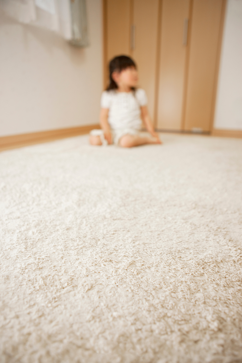 A little girl is sitting on the floor in a room.