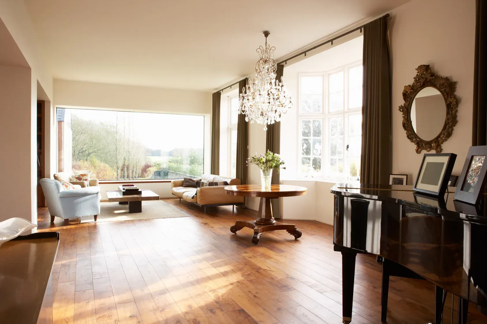 A living room with a piano and a chandelier