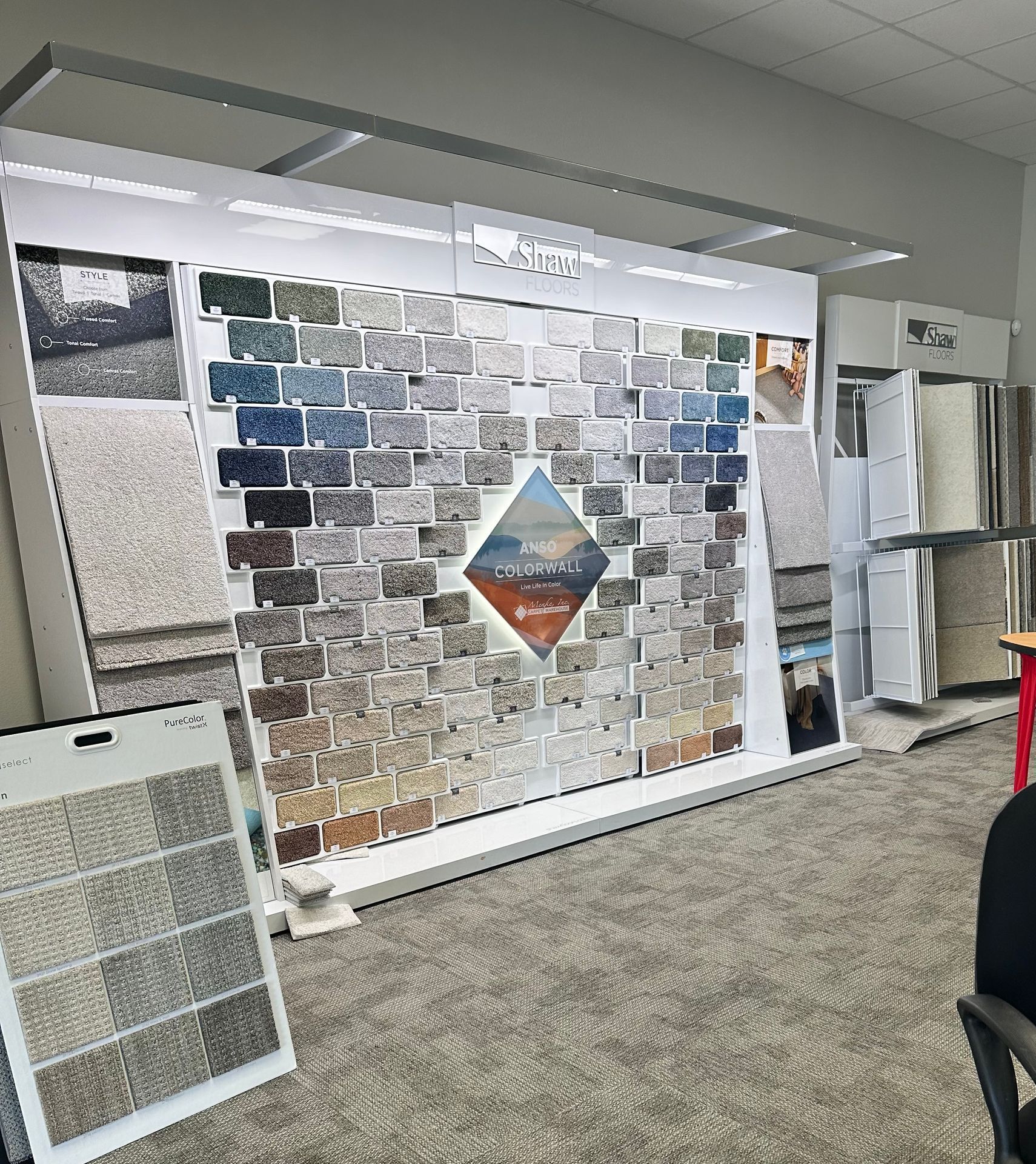 A carpet showroom with a large wall of carpet samples.