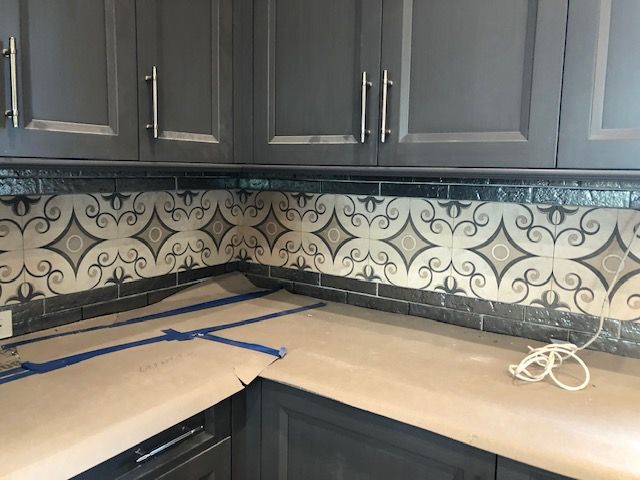 A kitchen with gray cabinets and a blue tape measure on the counter.